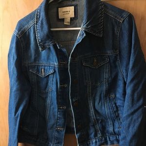 Blue Jean jacket with rip in sleeve.